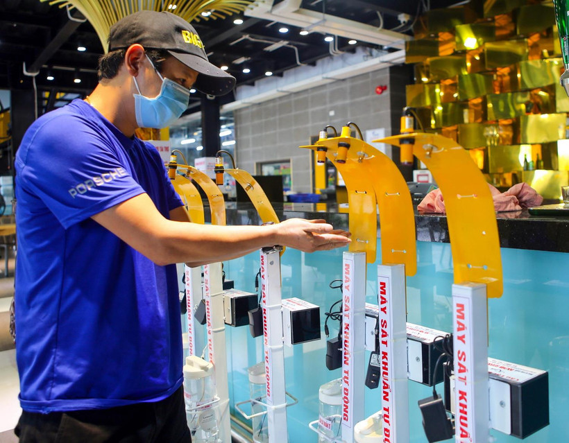 Anh Phạm Đức Dương, thành viên Ban sáng lập Câu lạc bộ Weekend đang kiểm tra máy xịt sát khuẩn “không chạm” để đưa đi trao tặng cho lực lượng phòng, chống dịch tại Đà Nẵng. (Ảnh: Trần Lê Lâm/TTXVN)