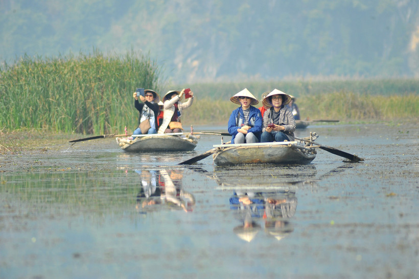 Du khách trong và ngoài nước tham quan khu bảo tồn thiên nhiên đất ngập nước Vân Long bằng thuyền. (Ảnh: Minh Đức/TTXVN)