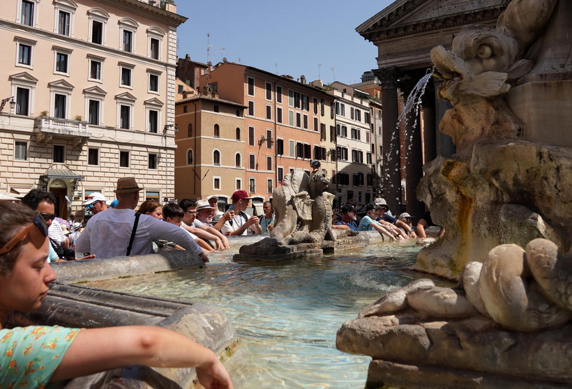 Khách du lịch tránh nóng bên đài phun nước tại Rome, Italy. (Ảnh: THX/TTXVN)