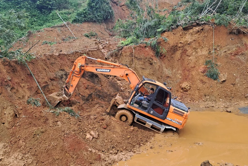 Các phương tiện máy móc tập trung xử lý hàng ngàn mét khối bùn đất trong vụ sạt lở. (Ảnh Đức Thọ/TTXVN)