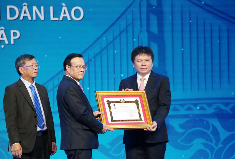 Phó Thủ tướng chính phủ Lào Somdee Duangdee (giữa) trao tặng Huân chương Lao động hạng Nhất cho LaoVietBank. (Ảnh: Xuân Tú/TTXVN)