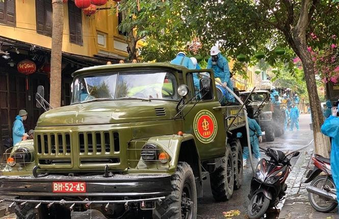 Lực lượng quân đội phun hóa chất khử trùng trên các tuyến phố trọng điểm ở phố cổ Hội An. (Ảnh: Trịnh Bang Nhiệm/ TTXVN)