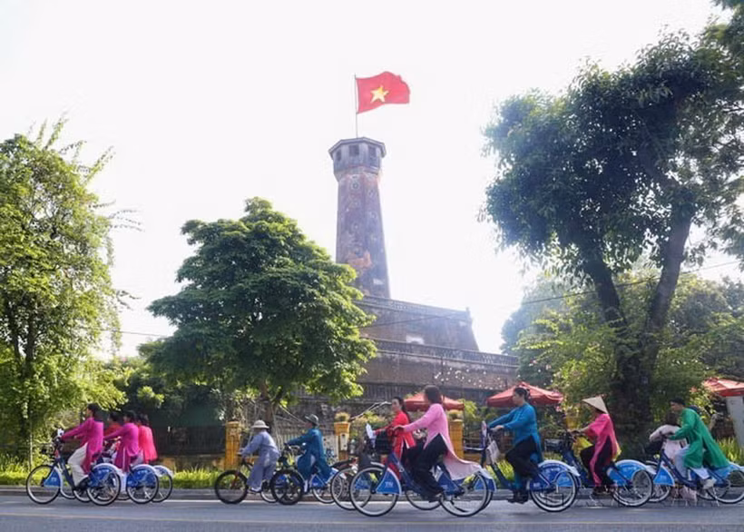 Hình ảnh hơn 100 nam, nữ trong trang phục áo dài cùng đạp xe qua các điểm du lịch di sản của Hà Nội, nhằm tăng cường quảng bá, giới thiệu các điểm đến của Thủ đô được các nhiếp ảnh gia ghi lại. (Ảnh: Minh Đức/TTXVN)