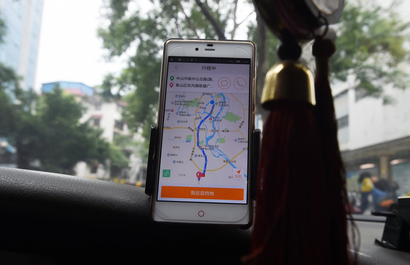 Tài xế taxi sử dụng ứng dụng gọi xe Didi Chuxing tại Quế Lâm, Trung Quốc. (Ảnh: AFP/TTXVN)