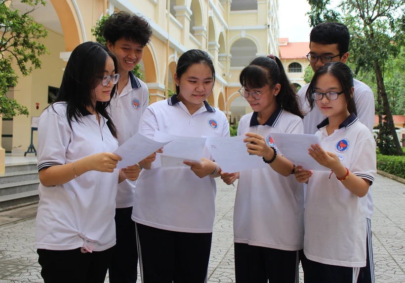 Các thí sinh trao đổi thông tin trước khi làm thủ tục dự thi Tốt nghiệp trung học phổ thông. (Ảnh: Hữu Chí/TTXVN)