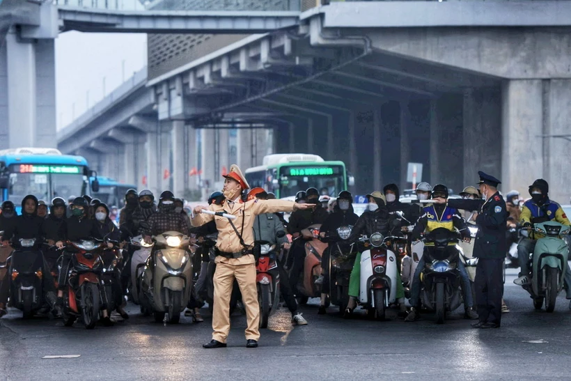 Lực lượng Cảnh sát Giao thông phân luồng các phương tiện để tránh ùn tắc tại ngã tư Nguyễn Xiển-Khuất Duy Tiến-Nguyễn Trãi. (Ảnh: Tuấn Anh/TTXVN)