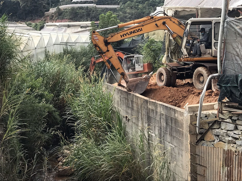 Lực lượng chức năng sử dụng phương tiện cơ giới để cưỡng chế công trình vi phạm xây dựng kiên cố. (Ảnh: TTXVN phát)