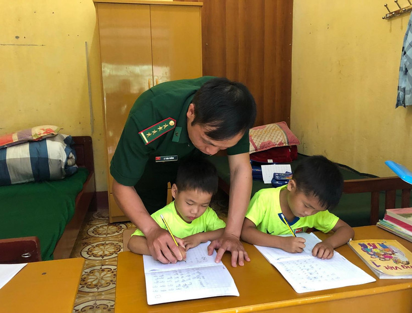 Cán bộ đồn biên phòng Xuân Trường dạy các "con nuôi" học bài. (Ảnh: Chu Hiệu/TTXVN)