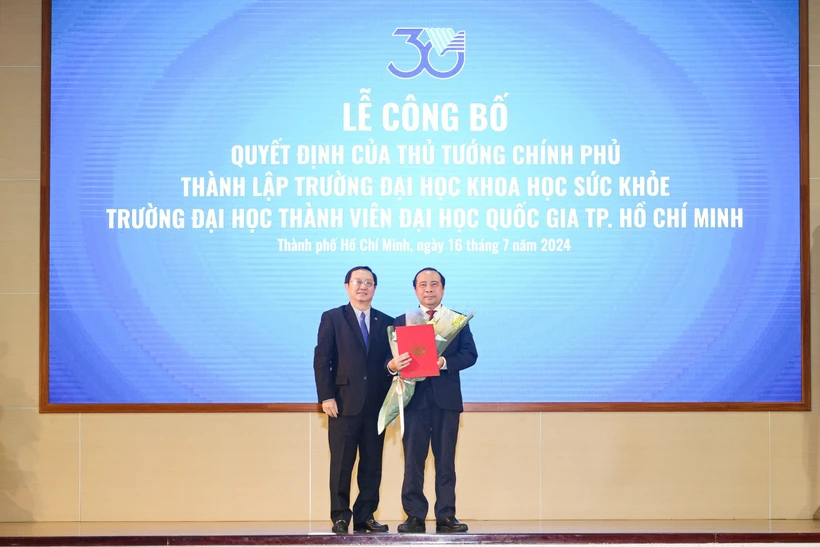 Phó Giáo sư, Tiến sỹ Huỳnh Thành Đạt, Bộ trưởng Bộ Khoa học và Công nghệ trao quyết định thành lập Trường Đại học Khoa học Sức khỏe cho Phó Giáo sư, Tiến sỹ Vũ Hải Quân. (Nguồn: Đại học Quốc gia Thành phố Hồ Chí Minh)