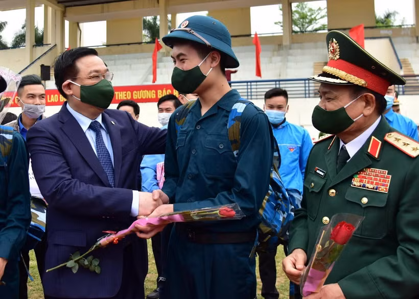 Bí thư Thành ủy Hà Nội Vương Đình Huệ tặng hoa, động viên các tân binh lên đường nhập ngũ. (Ảnh: TTXVN)