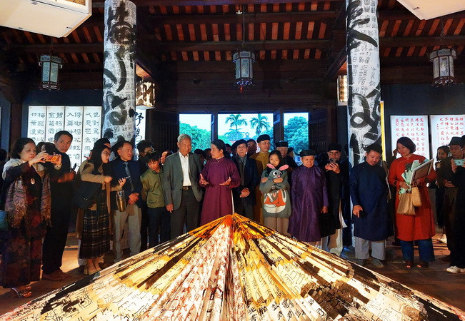 Công chúng thưởng lãm những tác phẩm thư pháp độc đáo ứng dụng công nghệ ánh sáng. (Ảnh: Đinh Thuận/TTXVN)