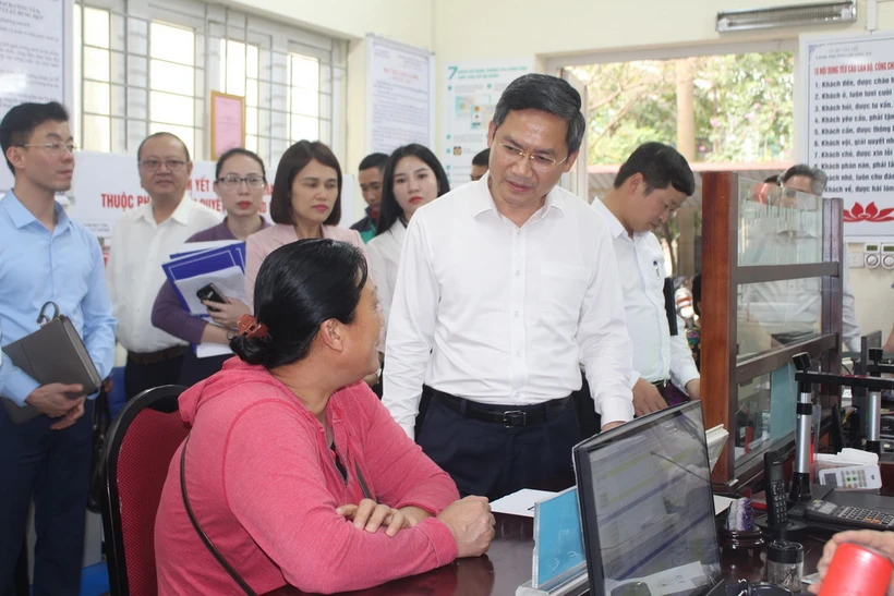 Phó Chủ tịch UBND thành phố Hà Nội Hà Minh Hải trao đổi với người dân làm thủ tục hành chính tại UBND phường Quảng An, quận Tây Hồ, Hà Nội. (Ảnh: Nguyễn Thắng/TTXVN)