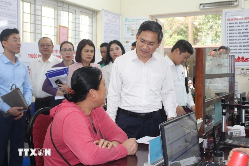 Phó Chủ tịch UBND thành phố Hà Nội Hà Minh Hải trao đổi với người dân làm thủ tục hành chính tại UBND phường Quảng An, quận Tây Hồ. (Ảnh: Nguyễn Thắng/TTXVN)