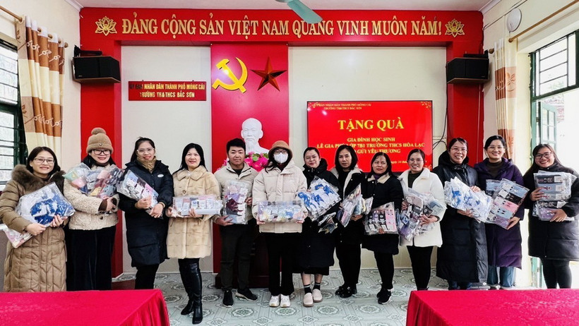Đại diện giáo viên nhà trường tiếp nhận quà của em Phú. (Ảnh: TTXVN phát)