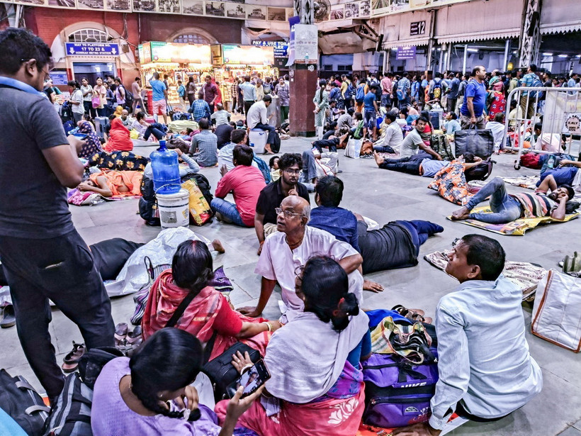 Hành khách chờ đợi tại nhà ga Hpwrah, Ấn Độ khi các chuyến tàu tạm dừng hoạt động do bão Dana. (Ảnh: ANI/TTXVN)