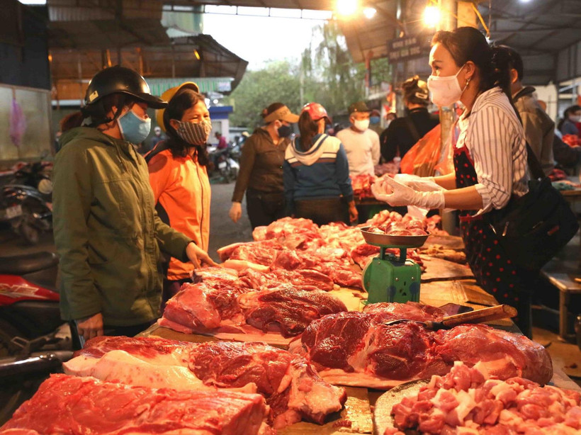 Người tiêu dùng mua thịt lợn tại chợ Phùng Khoang, quận Thanh Xuân, Hà Nội. (Ảnh: TTXVN)