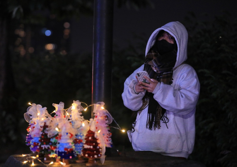 Một bạn trẻ bán đồ Giáng sinh trên đường Thanh Niên. (Ảnh: Hoàng Hiếu/TTXVN)