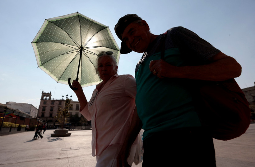 Người dân di chuyển dưới trời nắng nóng tại bang Jalisco, Mexico. (Ảnh: AFP/TTXVN)