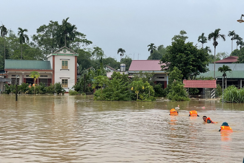 Lực lượng chức năng khẩn trương tiếp cận, di dời người dân và tài sản đến nơi an toàn. (Ảnh: Tạ Toàn/TTXVN)