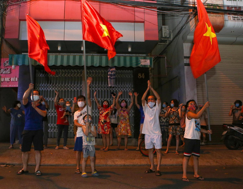 Người dân ở trên tuyến đường Nguyễn Thị Minh Khai vui mừng sau khi hoàn thành cách ly 14 ngày trong khu vực phong tỏa. (Ảnh: Trần Lê Lâm/TTXVN)