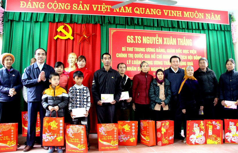 Ông Nguyễn Xuân Thắng trao quà cho các hộ nghèo, gia đình chính sách xã Tân Tiến. (Ảnh: Quang Cường/TTXVN)