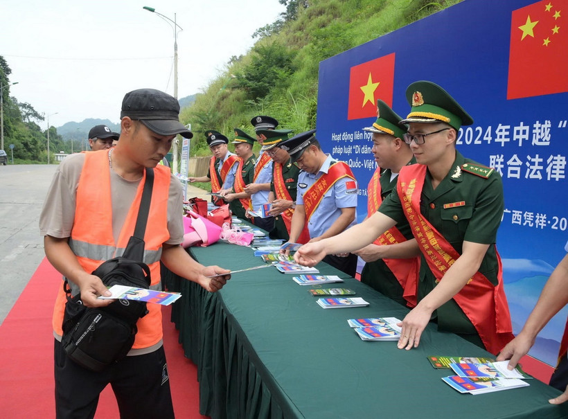 Cán bộ Đồn Biên phòng Tân Thanh, tỉnh Lạng Sơn, tuyên truyền, phát tờ rơi pháp luật biên giới tại cửa khẩu. (Ảnh: Quang Duy/TTXVN)