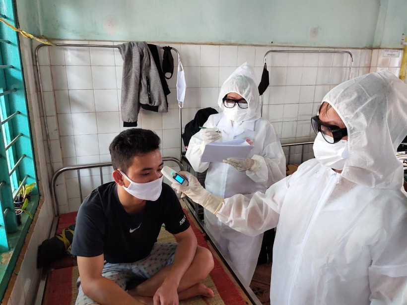 Nhân viên y tế đo thân nhiệt kiểm tra sức khỏe đối với công nhân phải cách ly. (Ảnh: Dương Chí Tưởng/TTXVN)