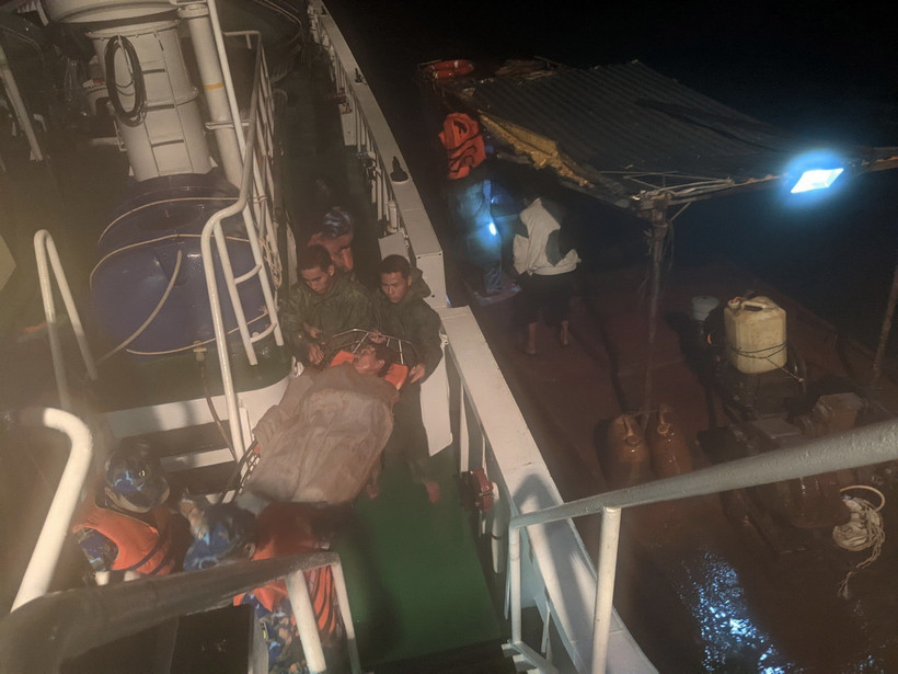 Chuyển bệnh nhân Nguyễn Văn Nhân từ tàu ngư dân lên tàu 468 (bên trái) để đưa về đảo Trường Sa điều trị bệnh. (Ảnh: TTXVN phát)