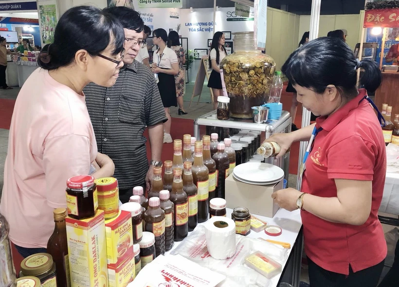 Các cơ sở làng nghề tư vấn người tiêu dùng cách thức phân biệt sản phẩm nông sản thật-giả. (Ảnh: Mỹ Phương/TTXVN)