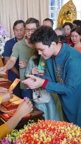 Trưởng lão Hòa thượng Thích Thiện Nhơn – Phó Pháp chủ Hội đồng Chứng minh, Chủ tịch Hội đồng Trị sự Giáo hội Phật giáo Việt Nam lì xì năm mới cho các phật tử đến Chùa Minh Đạo. (Ảnh: Khánh Ly/Vietnam+)