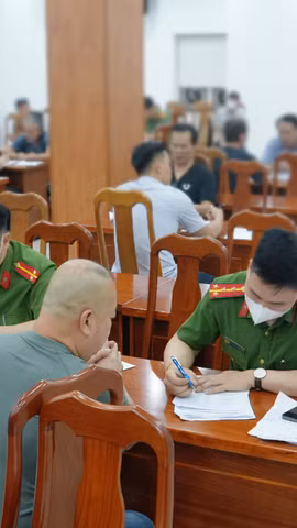 Một số công dân đang khai tờ khai về việc bị trục xuất về nước. (Ảnh: CA Thành phố Hồ Chí Minh cung cấp)