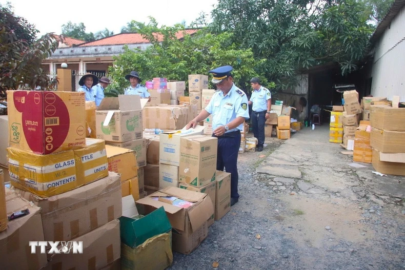 Lực lượng quản lý thị trường tỉnh Tây Ninh kiểm tra kho hàng tại hộ kinh doanh B.N. (ấp Bà Phổ, xã Thủ Thừa, tỉnh Tây Ninh) nghi giả mạo nhãn hiệu, không rõ nguồn gốc. (Ảnh: Minh Phú/TTXVN)