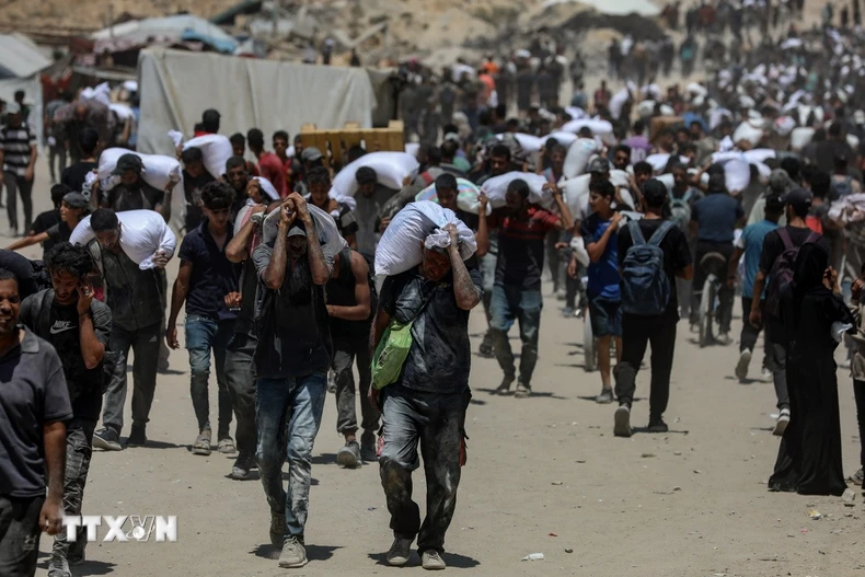 Người dân Palestine nhận hàng viện trợ nhân đạo tại Beit Lahia, phía Bắc Dải Gaza, ngày 1/8/2025. (Ảnh: THX/TTXVN)