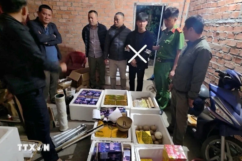 Cơ quan chức năng khám xét nơi cất giữ pháo nổ của đối tượng Phong. (Ảnh: TTXVN phát)