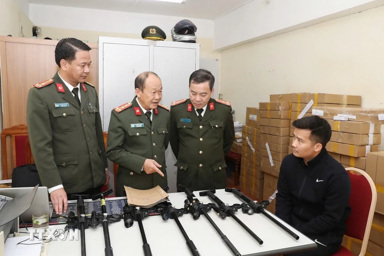 Đối tượng Vi Văn Duy (ngồi) cùng tang vật bị thu giữ. (Ảnh: TTXVN phát)