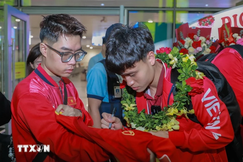 Cầu thủ đội tuyển bóng đá Việt Nam ký tặng người hâm mộ. (Ảnh: Phan Phương/TTXVN)