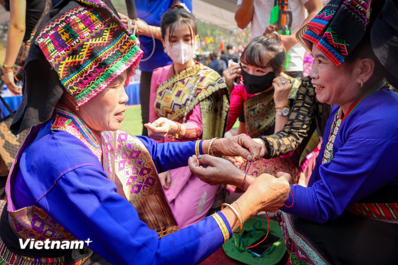 Tục buộc chỉ cổ tay cầu mong may mắn trong Lễ hội té nước hay còn gọi là Bun huột nặm của người Lào ở Điện Biên để chào đón năm mới. (Ảnh: Hoài Nam/Vietnam+)