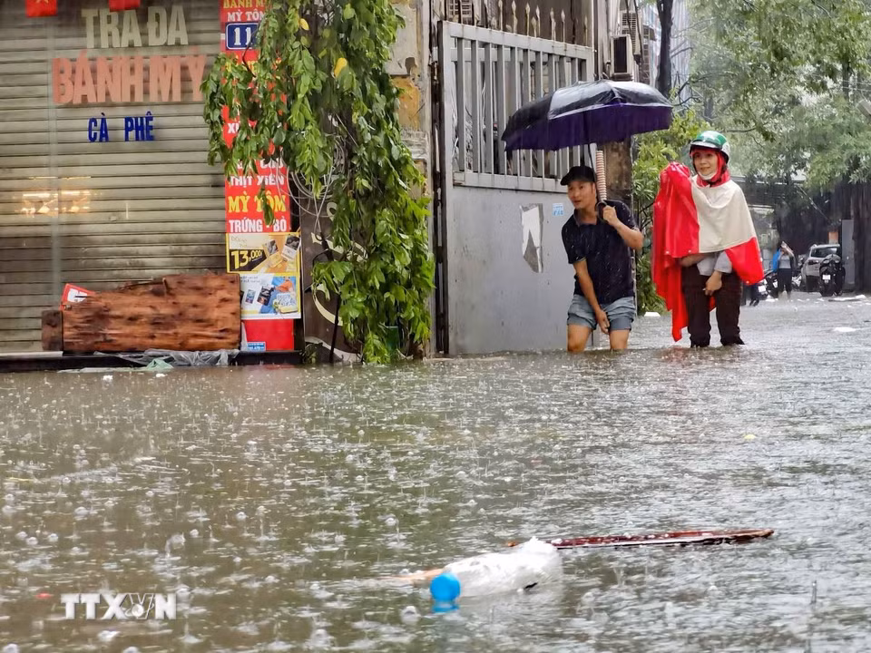 Ngập úng tại phố Mạc Thị Bưởi, người dân khó khăn khi di chuyển (chiều 30/9/2025). (Ảnh: Thanh Tùng/TTXVN)