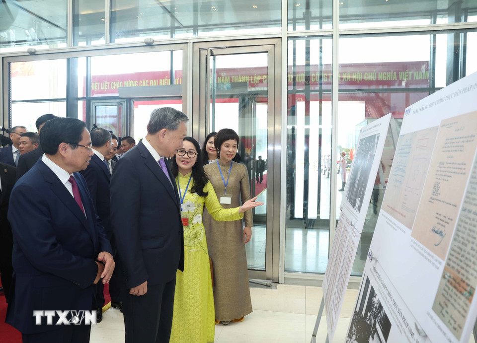 Tổng Bí thư Tô Lâm và Thủ tướng Phạm Minh Chính cùng các đại biểu tham quan trưng bày ảnh về hoạt động của Chính phủ qua các thời kỳ do TTXVN thực hiện. (Ảnh: Thống Nhất/TTXVN)