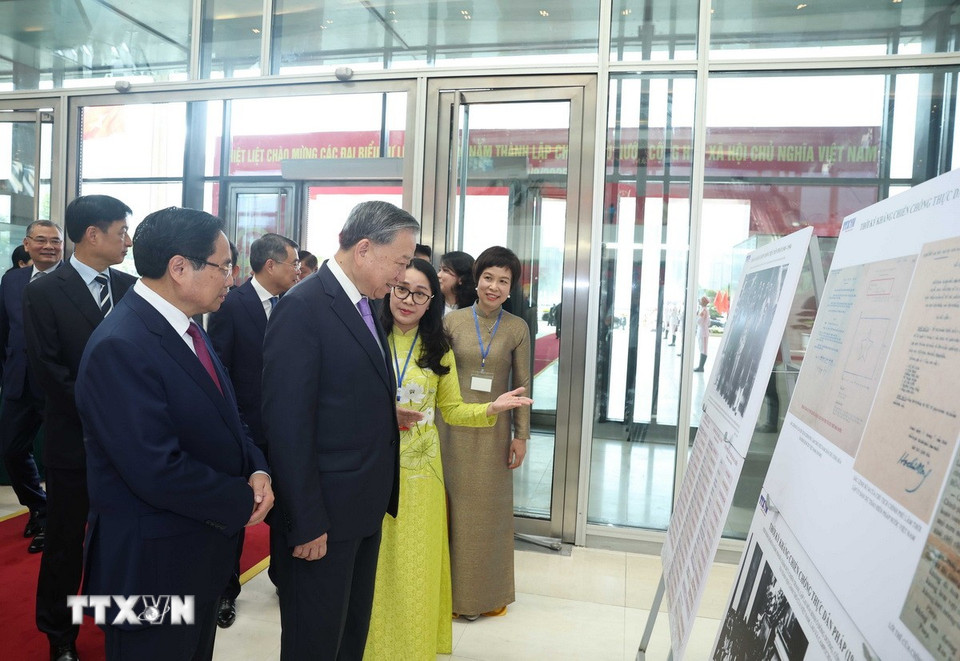 Tổng Bí thư Tô Lâm và Thủ tướng Phạm Minh Chính cùng các đại biểu tham quan trưng bày ảnh về hoạt động của Chính phủ qua các thời kỳ do TTXVN thực hiện. (Ảnh: Thống Nhất/TTXVN)