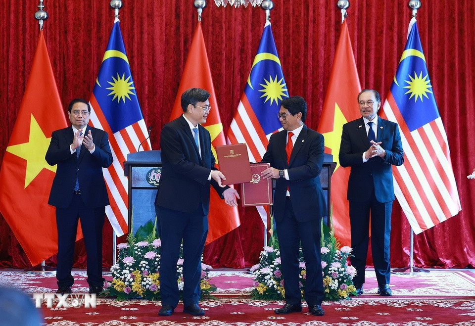 Thủ tướng Phạm Minh Chính và Thủ tướng Malaysia Anwar Ibrahim chứng kiến trao Ý định thư hợp tác giữa Đại học Quốc gia Thành phố Hồ Chí Minh và Đại học Quốc gia Malaysia. (Ảnh: Dương Giang/TTXVN)