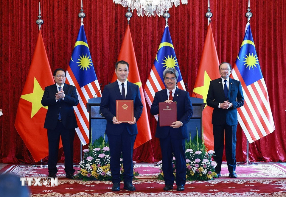 Thủ tướng Phạm Minh Chính và Thủ tướng Malaysia Anwar Ibrahim chứng kiến trao Ý định thư hợp tác giữa Đại học Quốc gia Hà Nội và Đại học Quốc gia Malaysia. (Ảnh: Dương Giang/TTXVN)