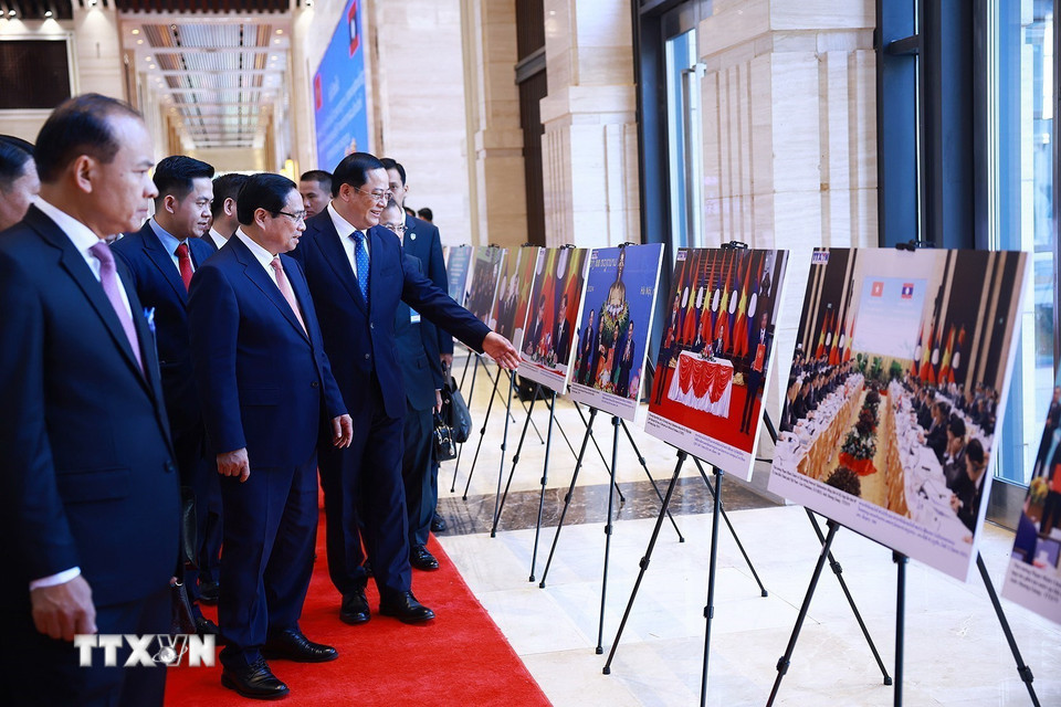 Thủ tướng Phạm Minh Chính và Thủ tướng Lào Sonexay Siphandone tham quan trưng bày ảnh về hợp tác giữa hai nước. (Ảnh: Dương Giang/TTXVN)
