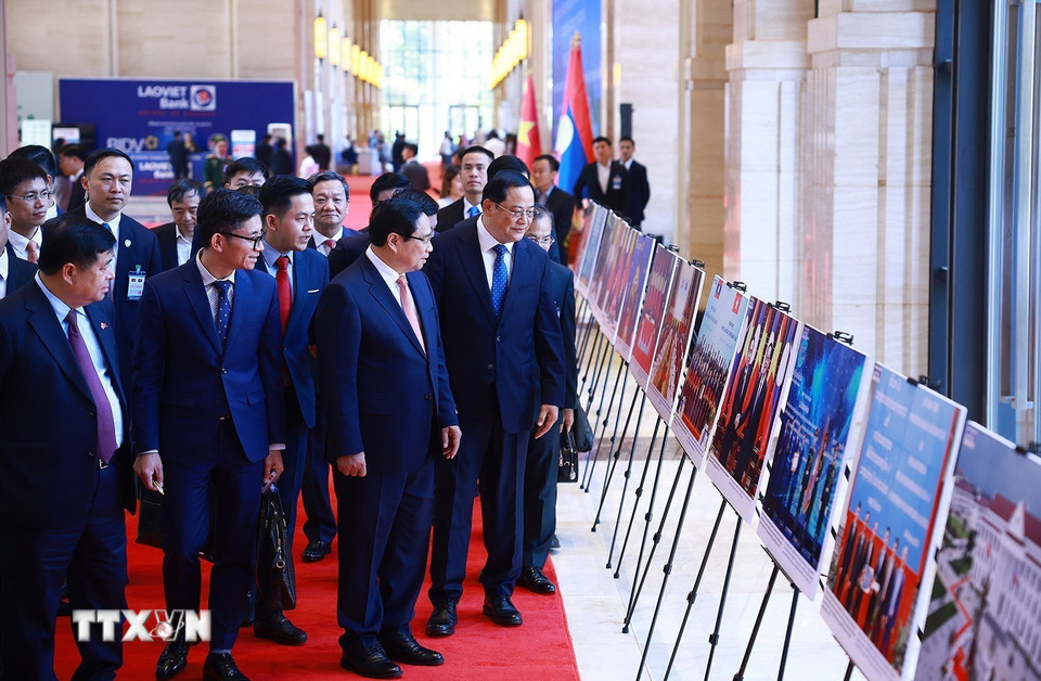 Thủ tướng Phạm Minh Chính và Thủ tướng Lào Sonexay Siphandone tham quan trưng bày ảnh về hợp tác giữa hai nước. (Ảnh: Dương Giang/TTXVN)