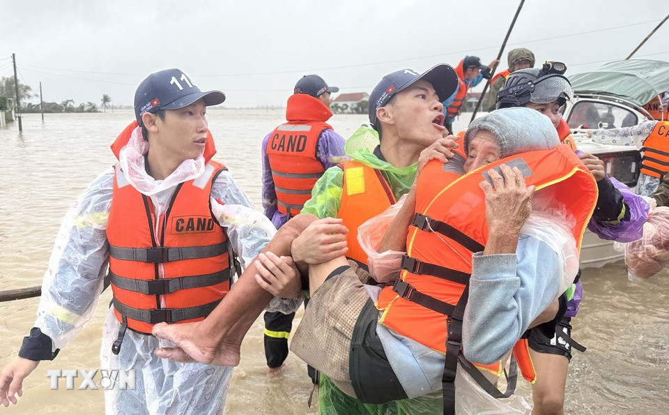 Lực lượng chức năng sơ tán một cụ già trong vùng ngập lũ ở xã Hòa Thịnh, Đắk Lắk đến nơi an toàn. (Ảnh: Tường Quân/TTXVN)