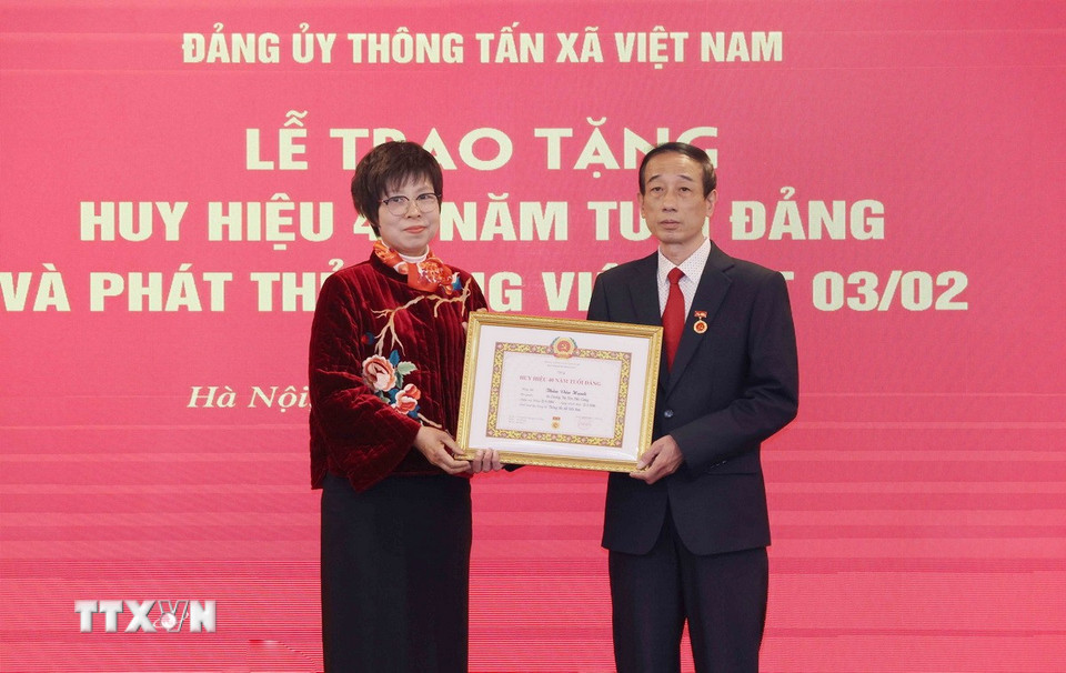 Bà Vũ Việt Trang, Ủy viên Ban Chấp hành Đảng bộ Khối các cơ quan Trung ương, Bí thư Đảng ủy, Tổng Giám đốc Thông tấn xã Việt Nam trao Huy hiệu 40 năm tuổi Đảng cho ông Thân Văn Hạnh. (Ảnh: Phương Hoa/TTXVN)