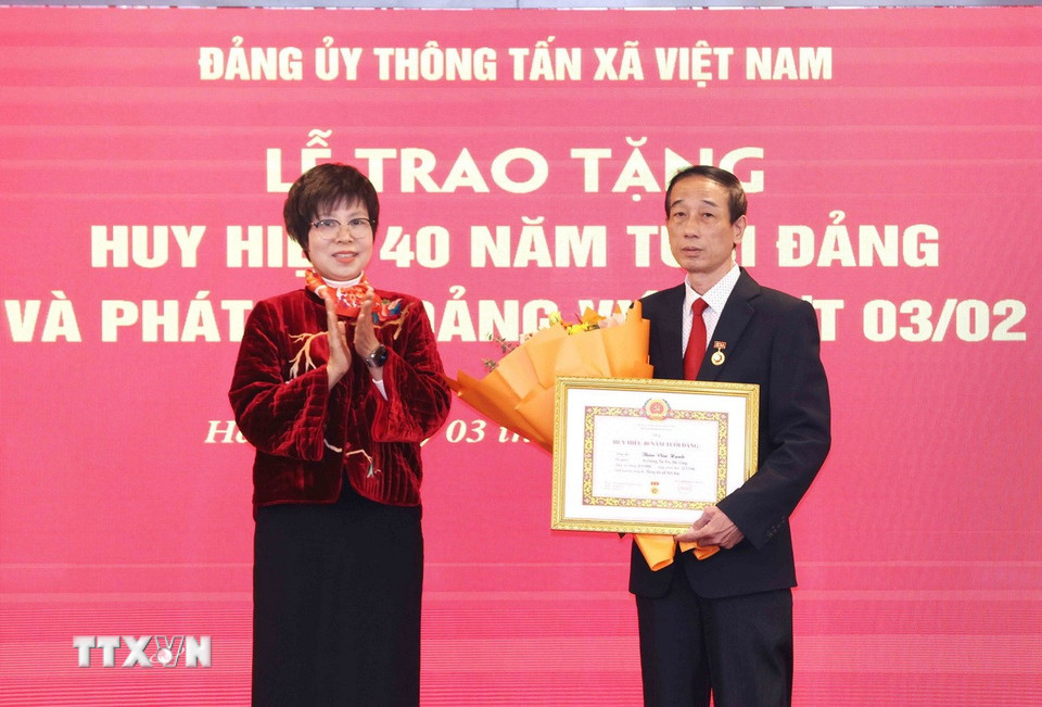 Bà Vũ Việt Trang, Ủy viên Ban Chấp hành Đảng bộ Khối các cơ quan Trung ương, Bí thư Đảng ủy, Tổng Giám đốc Thông tấn xã Việt Nam trao Huy hiệu 40 năm tuổi Đảng cho ông Thân Văn Hạnh. (Ảnh: Phương Hoa/TTXVN)
