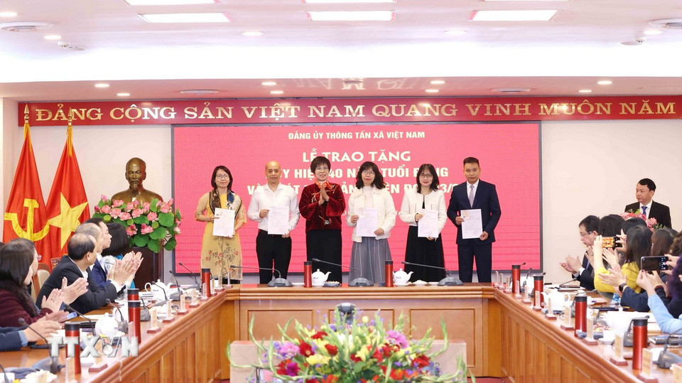 Bà Vũ Việt Trang, Ủy viên Ban Chấp hành Đảng bộ Khối các cơ quan Trung ương, Bí thư Đảng ủy, Tổng Giám đốc Thông tấn xã Việt Nam trao thẻ đảng viên cho các đảng viên. (Ảnh: Phương Hoa/TTXVN)