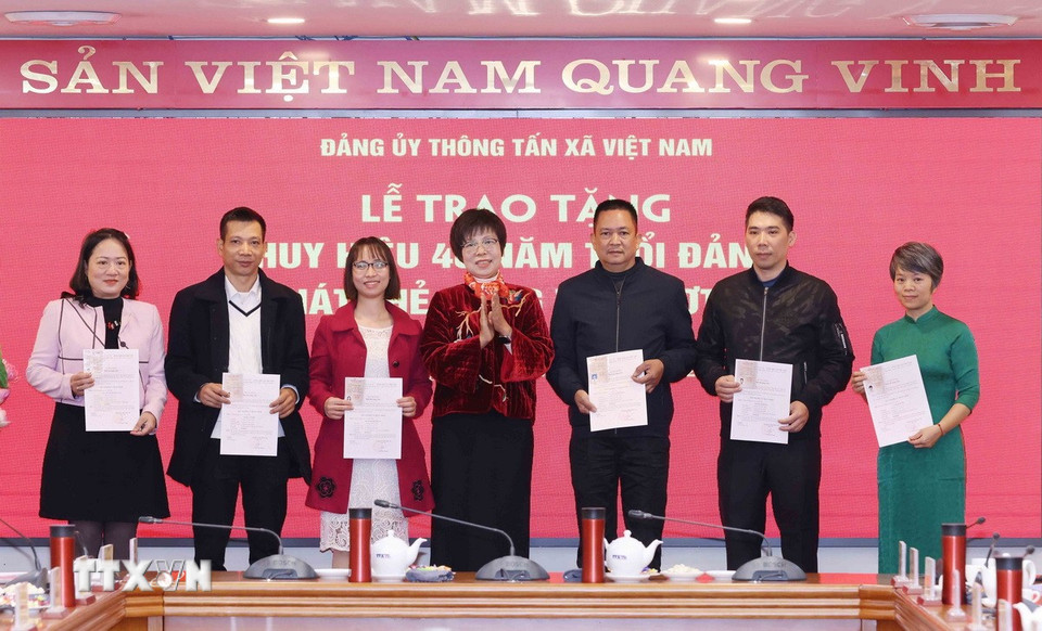 Bà Vũ Việt Trang, Ủy viên Ban Chấp hành Đảng bộ Khối các cơ quan Trung ương, Bí thư Đảng ủy, Tổng Giám đốc Thông tấn xã Việt Nam trao thẻ đảng viên cho các đảng viên. (Ảnh: Phương Hoa/TTXVN)
