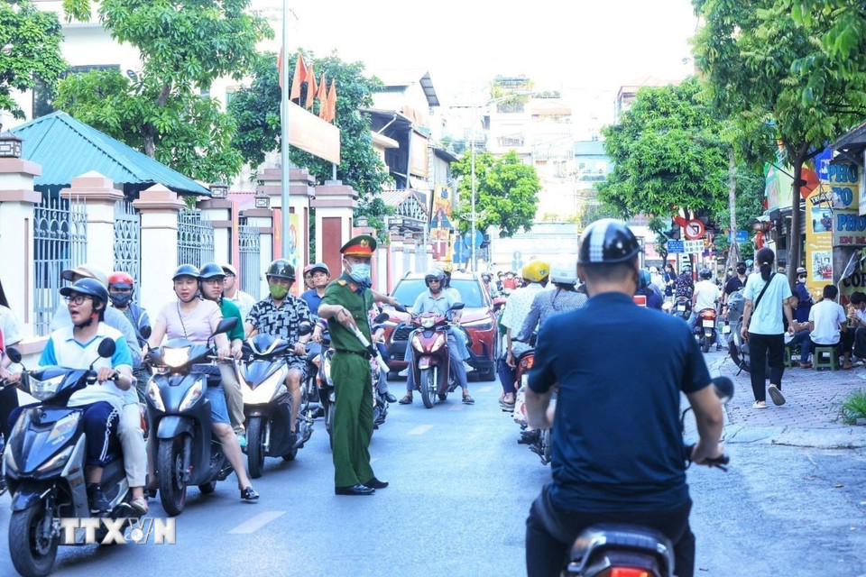 Lực lượng công an phường Khương Đình đảm bảo an toàn giao thông tại các điểm thi. (Ảnh: Tuấn Anh/TTXVN)